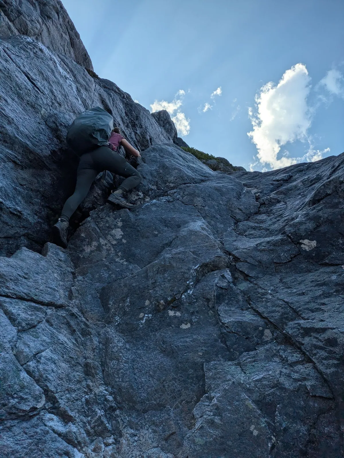 Personne qui escalade des rochers dans une montée raide