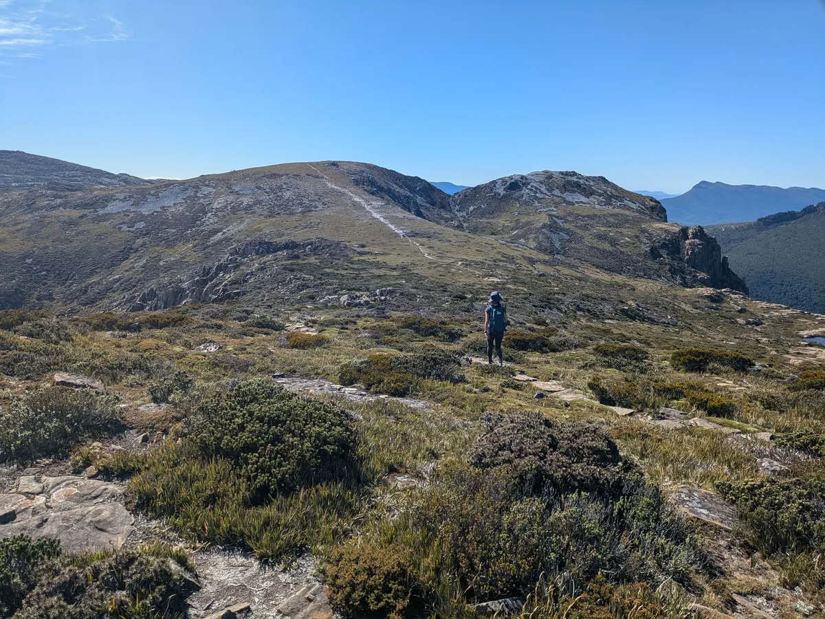 Un randonneur traversant un plateau alpin