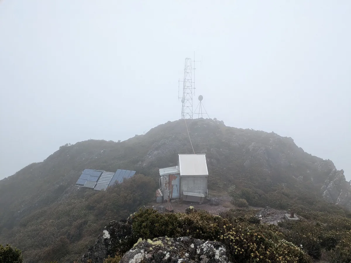 Sommet montagneux avec un abri en tôle et une antenne